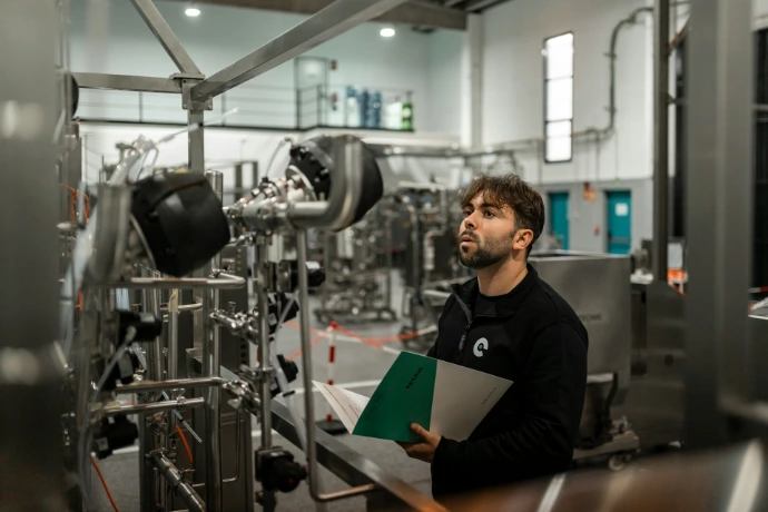 A man inspects machinery in a factory.